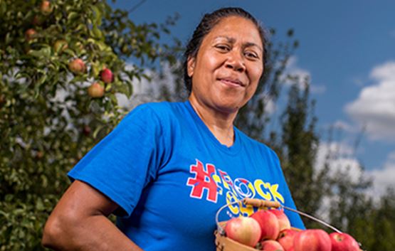 Woman carrying basket of apples